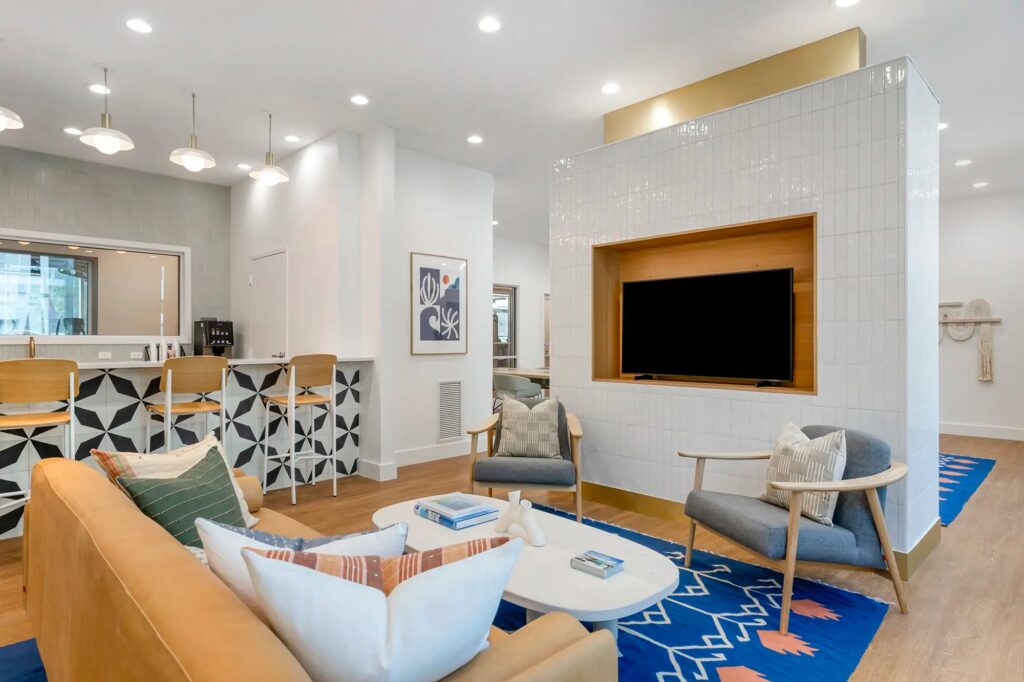 Clubhouse sitting area with couch and chairs with access to kitchen area and tc