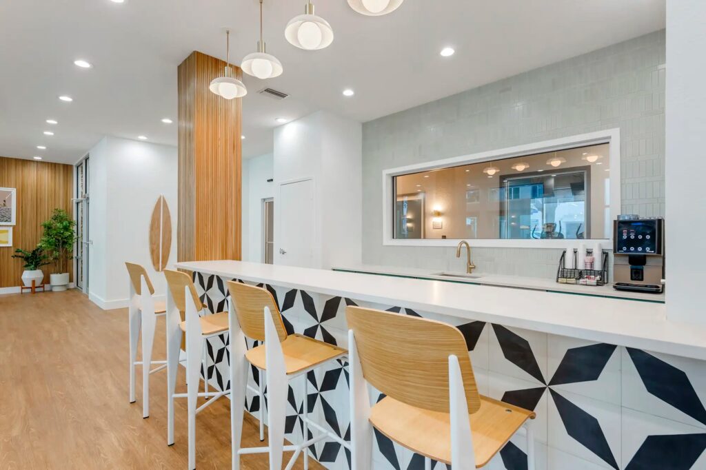 clubhouse kitchen area with coffee maker, sink, and barstool seating