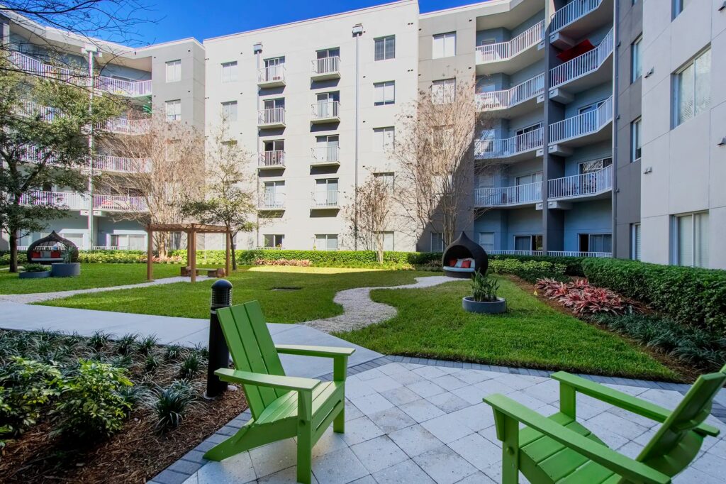 Courtyard with lots of grass and spaced out seating areas with different type of chairs
