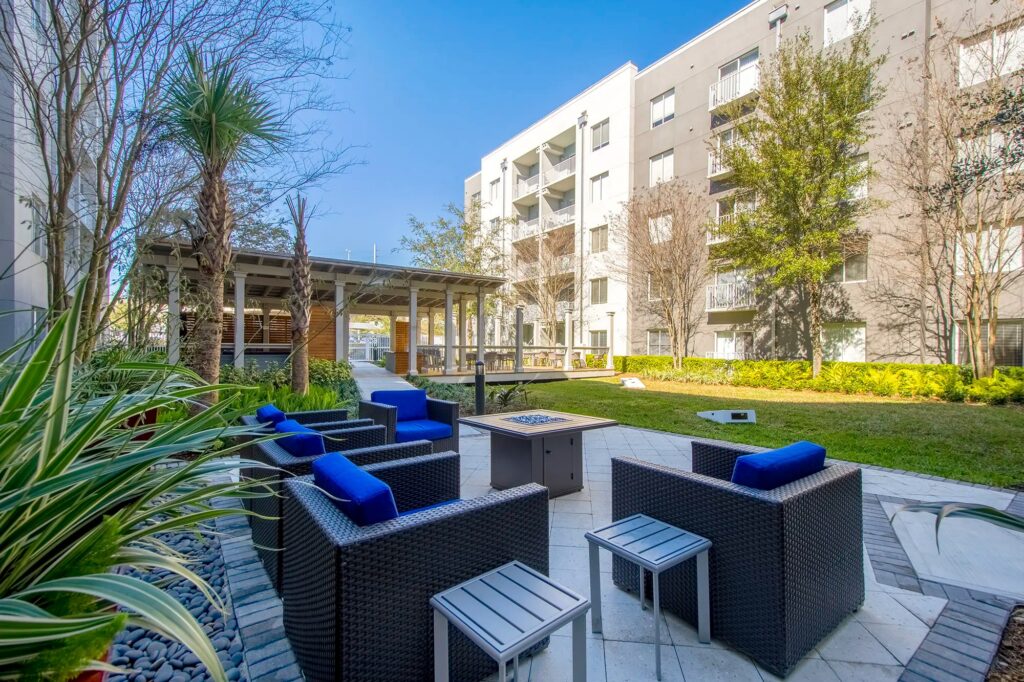 Courtyard with lots of grass and spaced out seating areas. With outdoor covered seating area