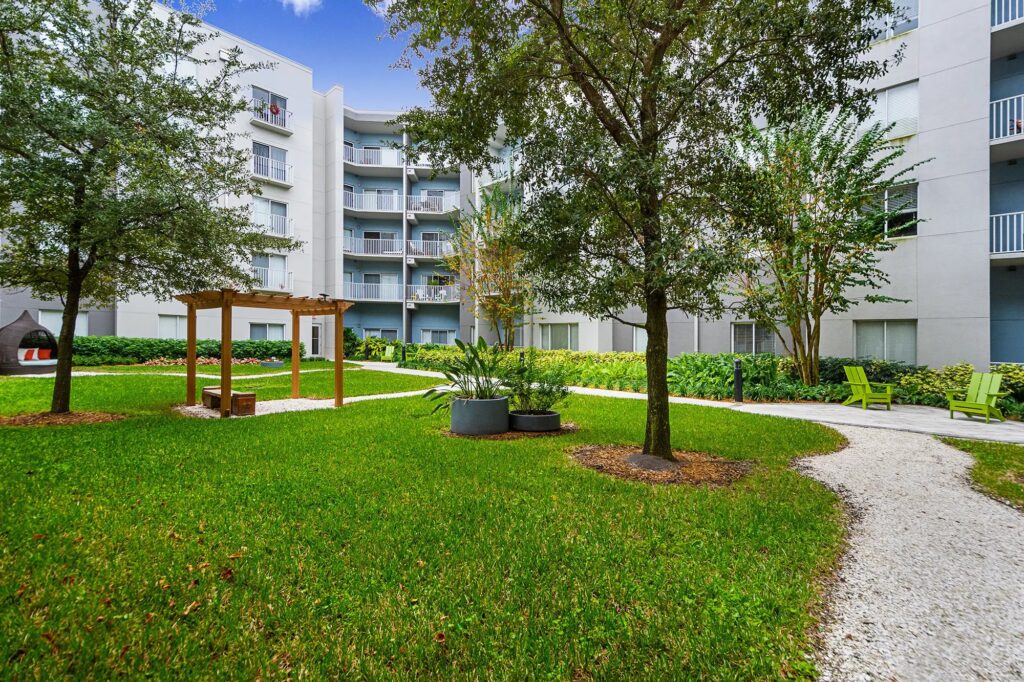 Courtyard with lots of grass and spaced out seating areas with gravel pathways leading.