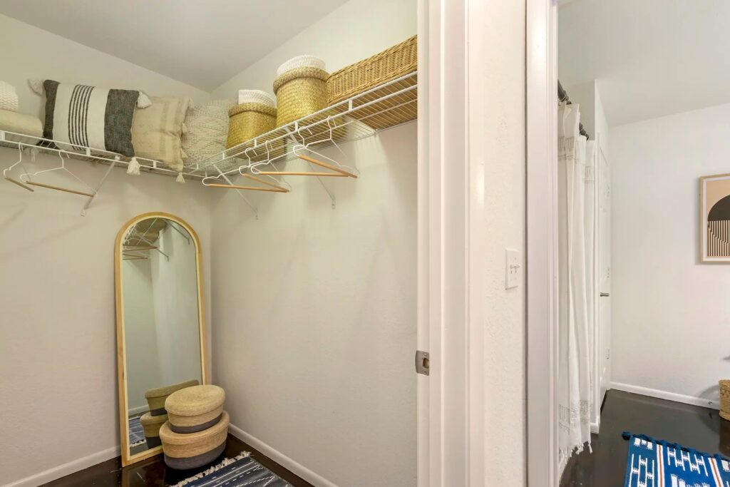 walk in closet with built in shelf with access to the bathroom